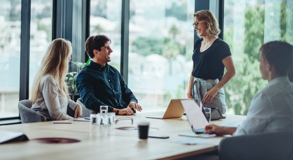 Group of happy corporate people in a meeting. Business man and woman discussing business in an office meeting.